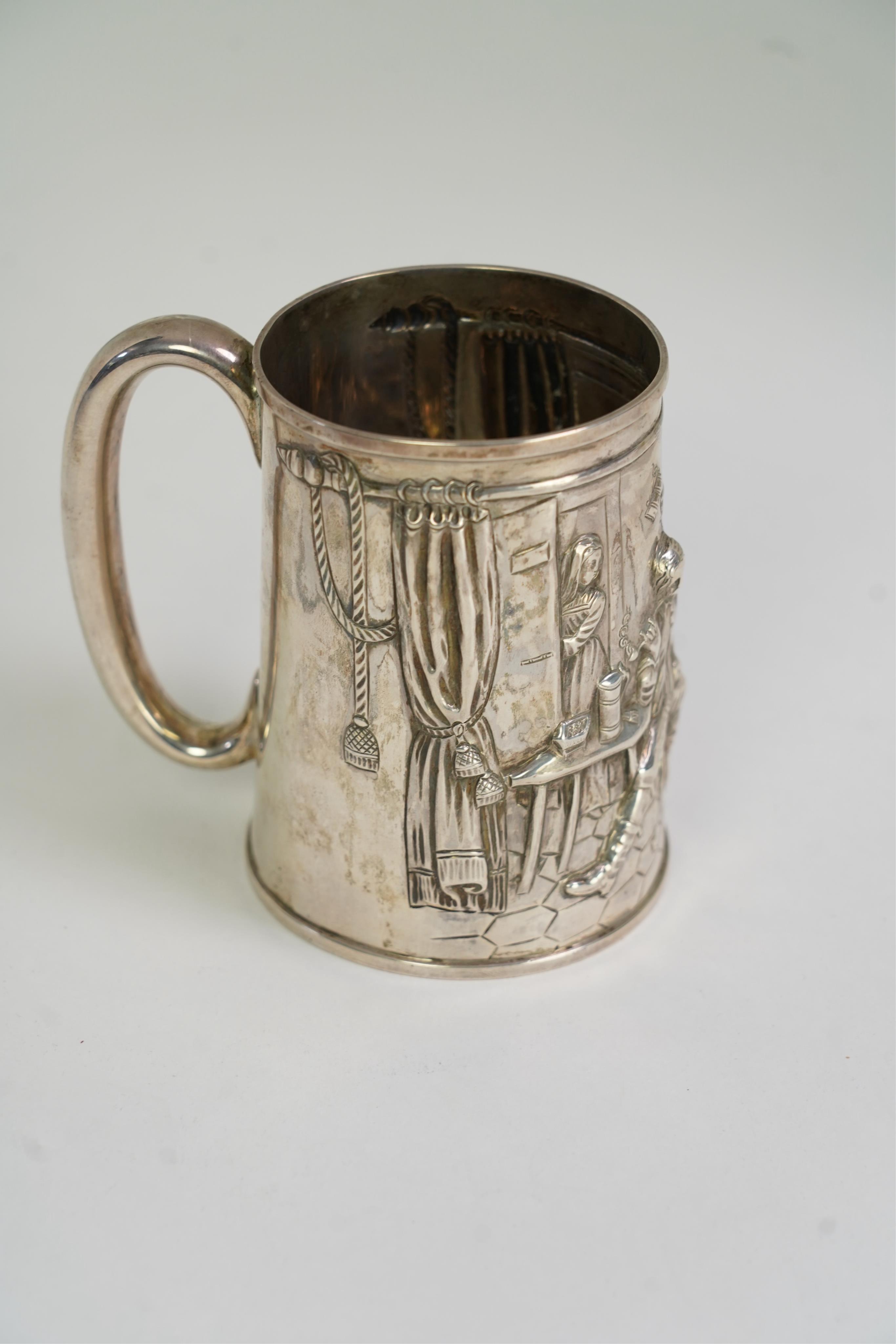 A Victorian silver mug, embossed with interior scene and imbibers, by John Harrison & Co